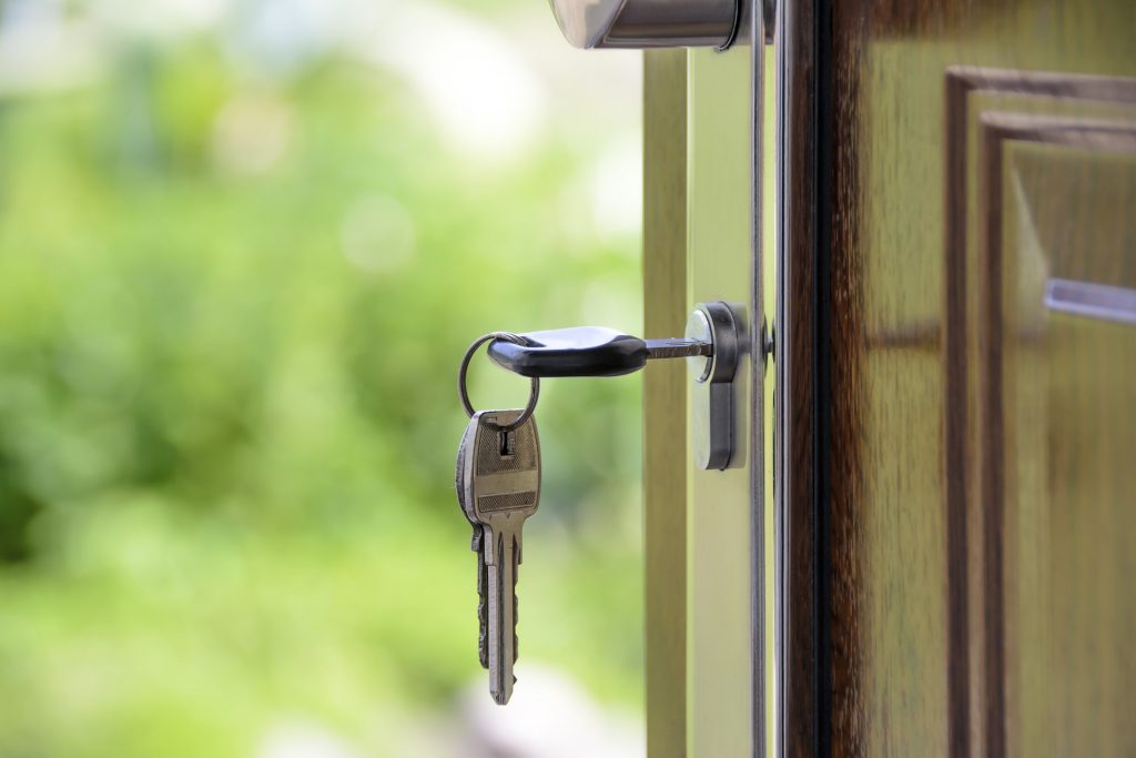 Porte d'entrée d'une maison ouverte avec les clés dans la serrure